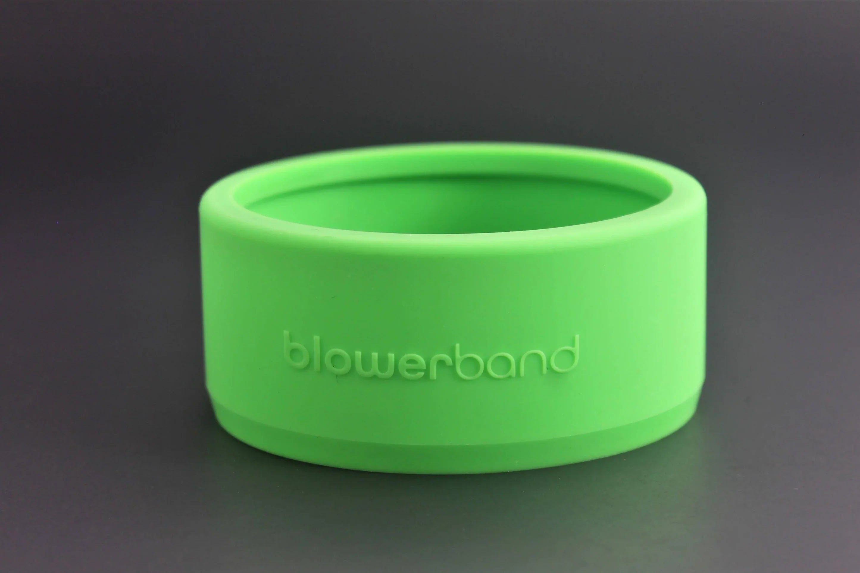 A bright green Blowerband® Guard for STUBBY Car Drying Nozzles, made of silicone and embossed with "Blowerband" on the front, displayed against a plain black background.