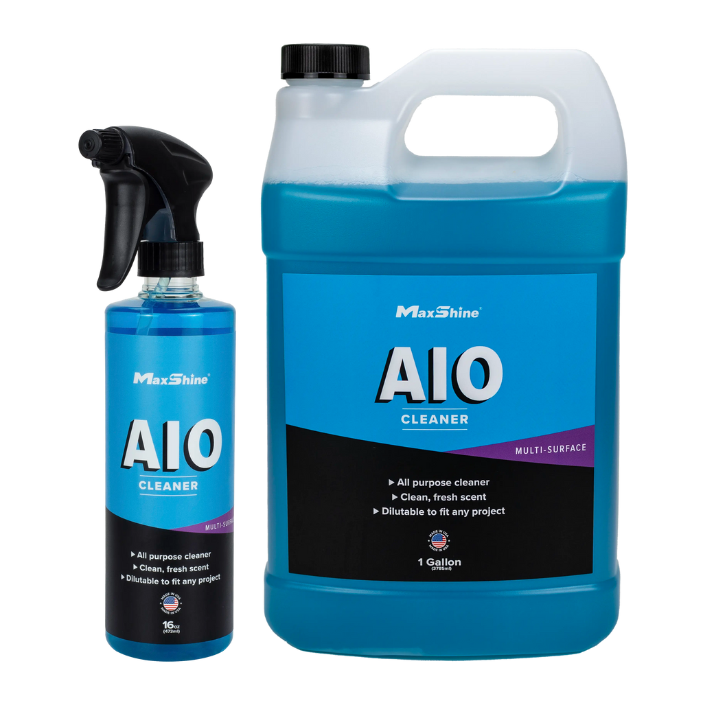Two bottles of MaxShine Interior Car Cleaner | AIO Cleaner (16oz spray and 1gal jug) with blue liquid are shown. Labels highlight their all-in-one car cleaning for multiple surfaces, offering a clean, fresh scent—ideal for detailing.