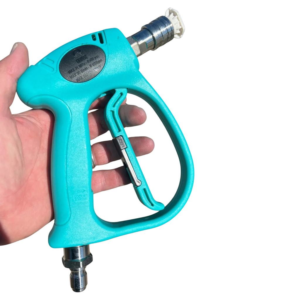 A hand holds the Quivr Pressure Washer Short Gun, a turquoise, corrosion-resistant spray gun with a metal nozzle, fluid swivel, and trigger, isolated on a white background.