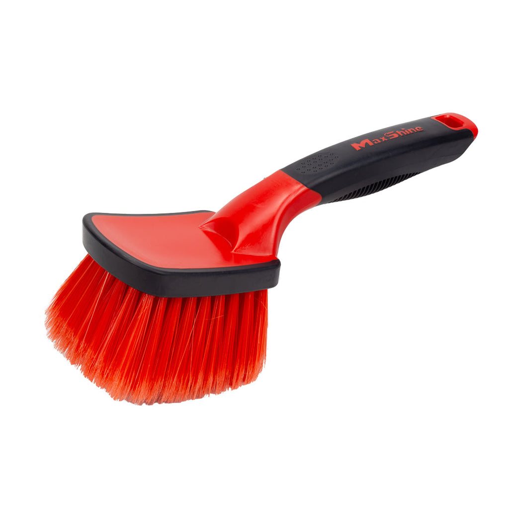 The Soft Grip Light Duty Rim Cleaning Brush features a medium handle and dense, angled bristles in red and black for easy, ergonomic scrubbing of surfaces.