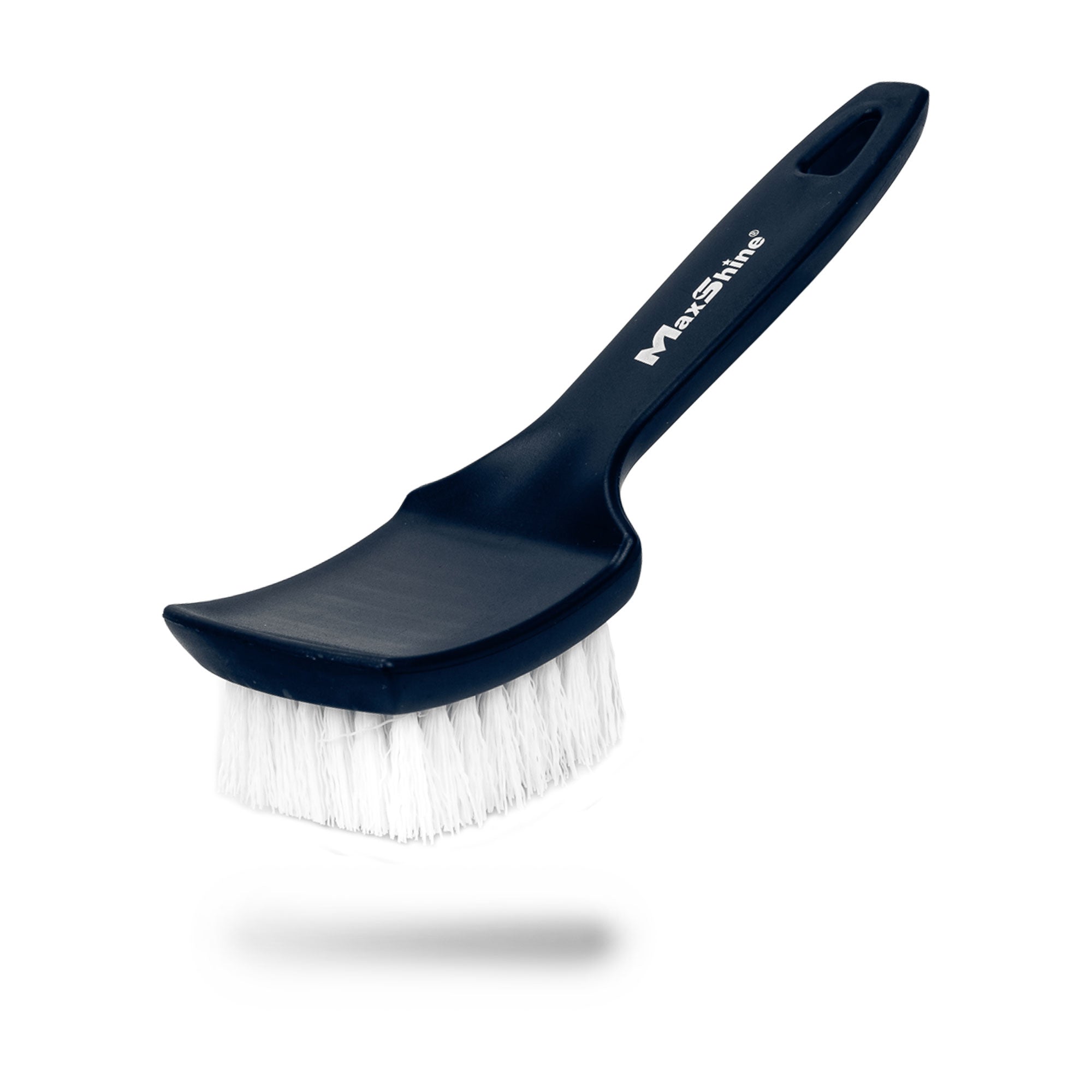 The Tire Scrub Brush, featuring stiff bristles and a curved handle with a hanging hole, is shown at an angle on a white background. The black brush casts a subtle shadow beneath it.