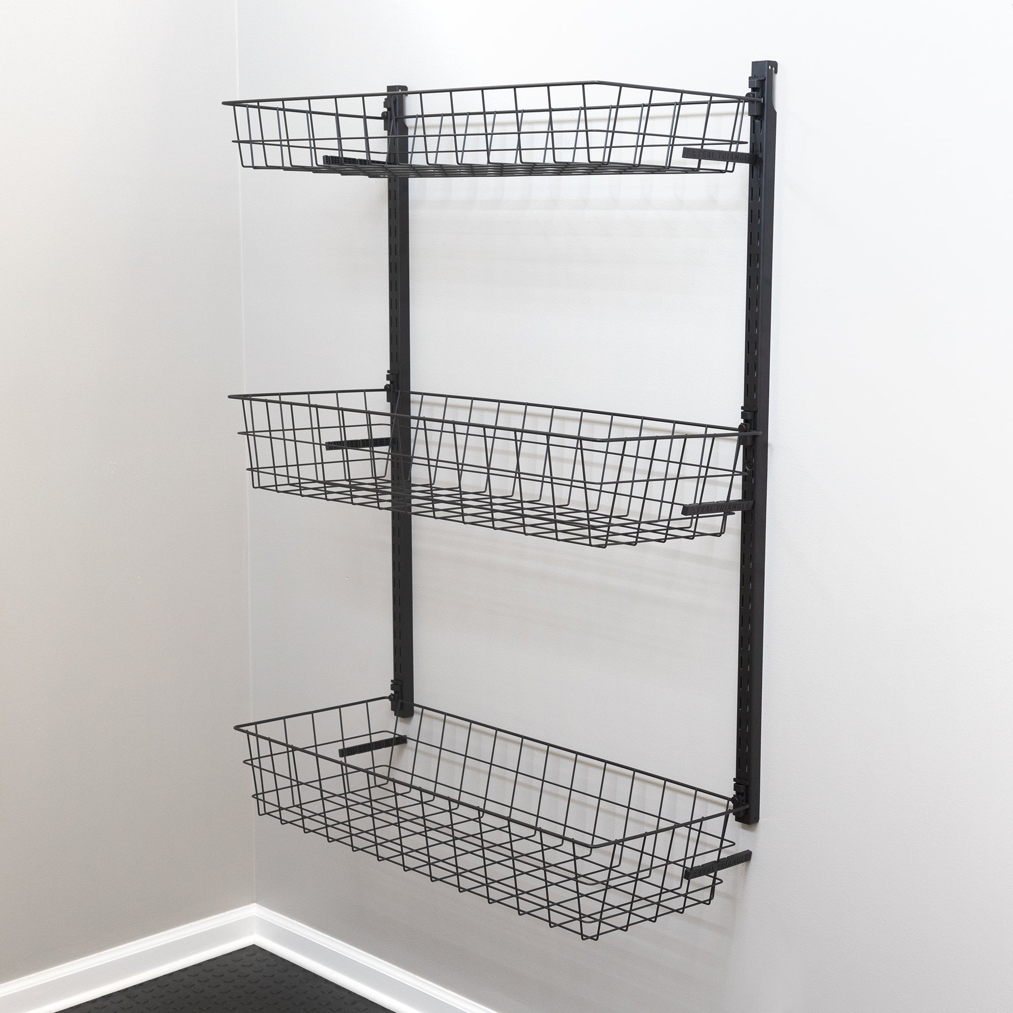 The G-Basket Adjustable Wall Storage System features three heavy-duty wire baskets on a black metal frame for stylish, practical corner storage. This organizer holds up to 120 lbs and is ideal for rooms with light-colored walls.