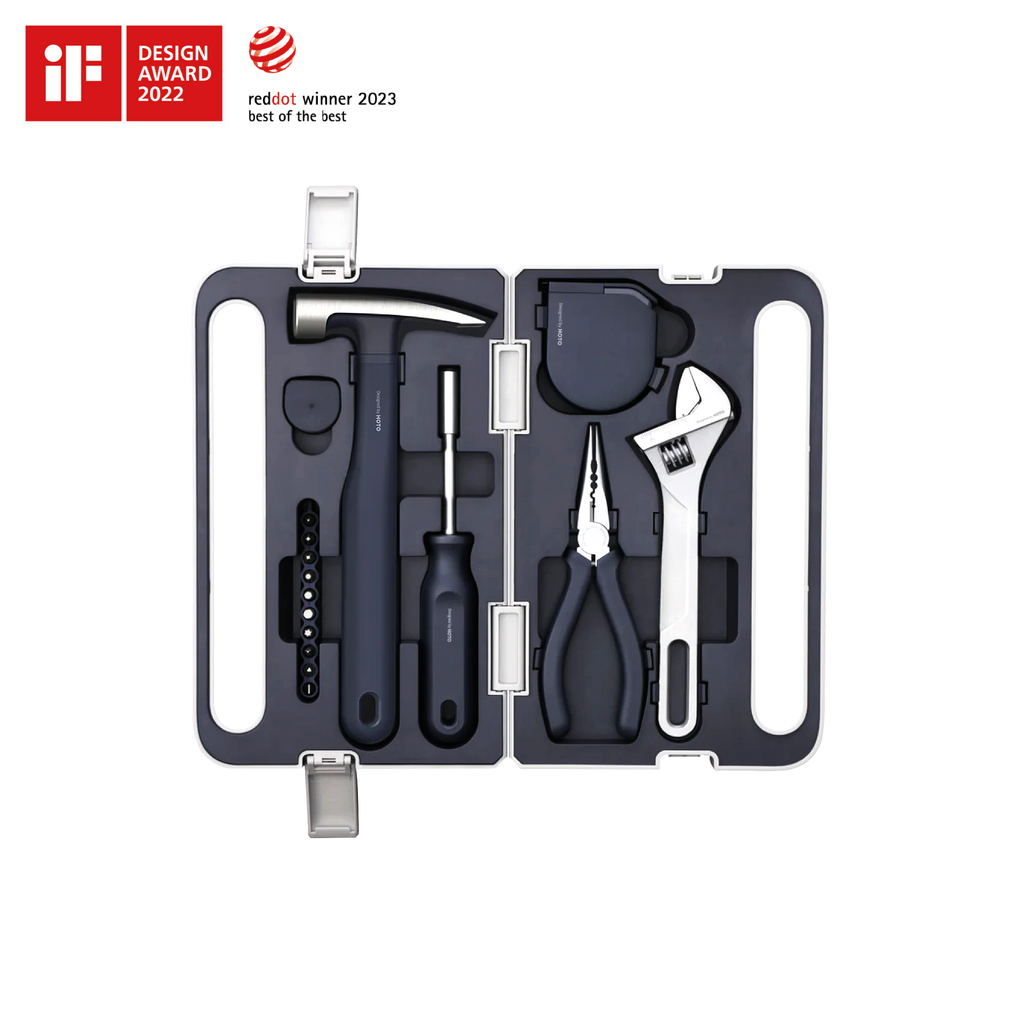 The Hand Tool Set is a compact black kit with a hammer, screwdriver, pliers, wrench, tape measure, and hex keys organized in a hard case. It features minimalist design and two design award logos displayed in the top left corner.