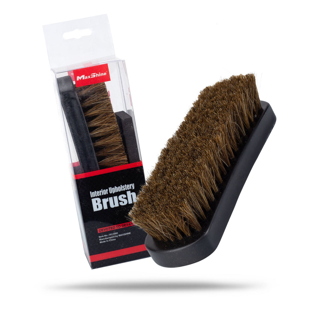 A brown-bristled Upholstery and Car Carpet Brush with a black handle, made with horsehair bristles, is shown beside its red, black, and white packaging—ideal for deep car interior cleaning.